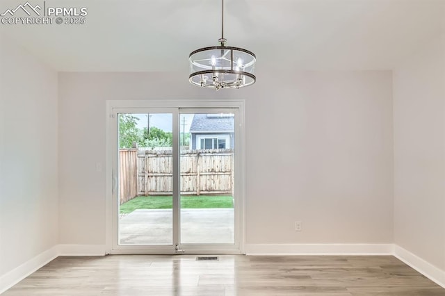 610 E San Gabriel Pl, Colorado Springs, CO 80906 - unfurnished room featuring a chandelier, baseboards, and light wood-type flooring