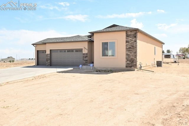 1213 E Tidy Dr, Pueblo, CO 81007 - view of front of house with stone siding, stucco siding, an attached garage, and concrete driveway