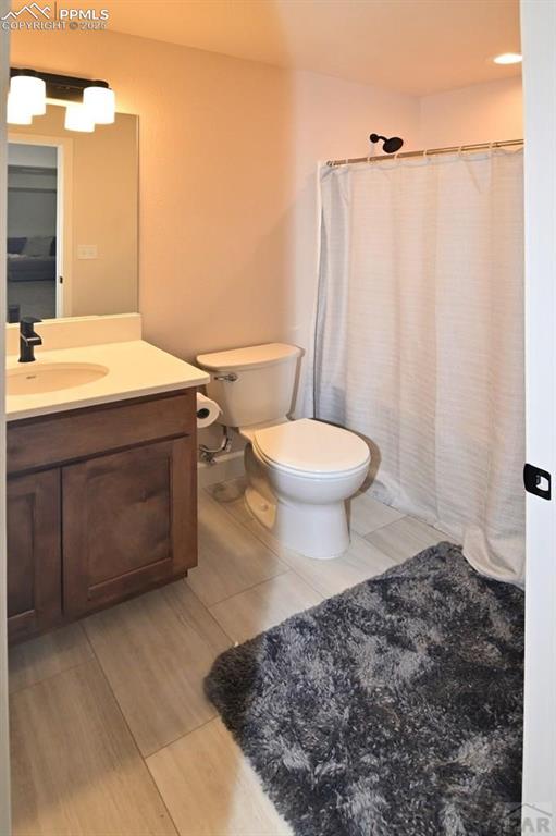 1213 E Tidy Dr, Pueblo, CO 81007 - bathroom featuring toilet, vanity, and a shower with shower curtain
