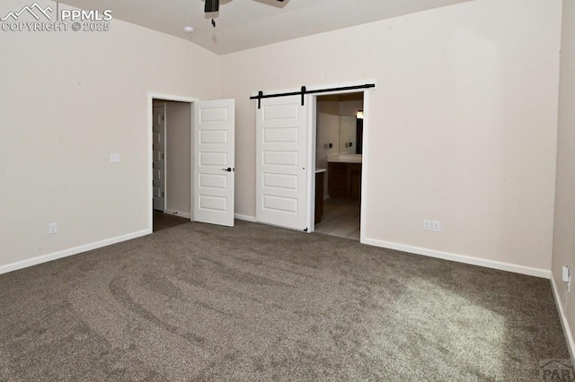 1213 E Tidy Dr, Pueblo, CO 81007 - unfurnished bedroom featuring carpet, baseboards, a barn door, and connected bathroom