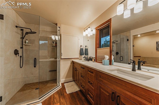 5145 Golden Hills Ct, Colorado Springs, CO 80919 - bathroom with a stall shower, wood finished floors, double vanity, and a chandelier