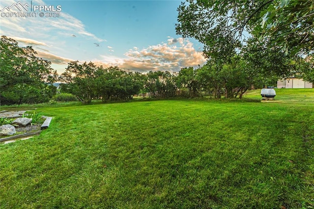 5145 Golden Hills Ct, Colorado Springs, CO 80919 - yard at dusk featuring a lawn and view of wooded area