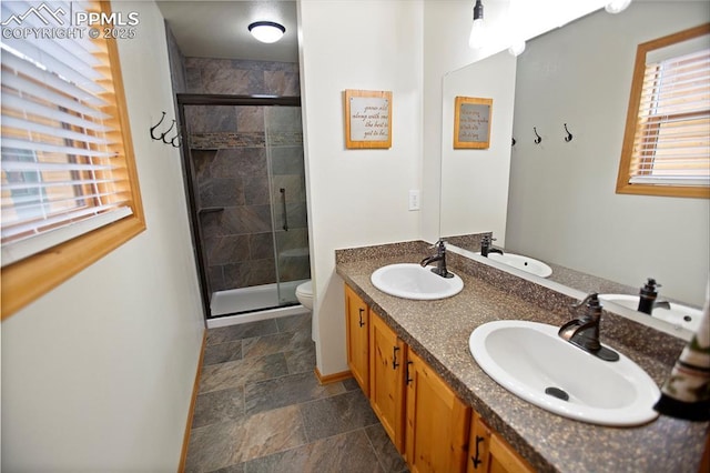 409 Pike View Dr, Divide, CO 80814 - full bathroom with toilet, double vanity, stone finish floors, and a stall shower