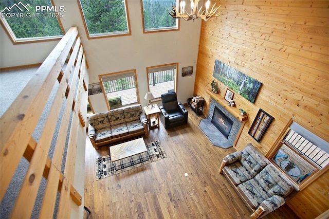 409 Pike View Dr, Divide, CO 80814 - living area with a high ceiling, a chandelier, wood walls, a glass covered fireplace, and wood finished floors
