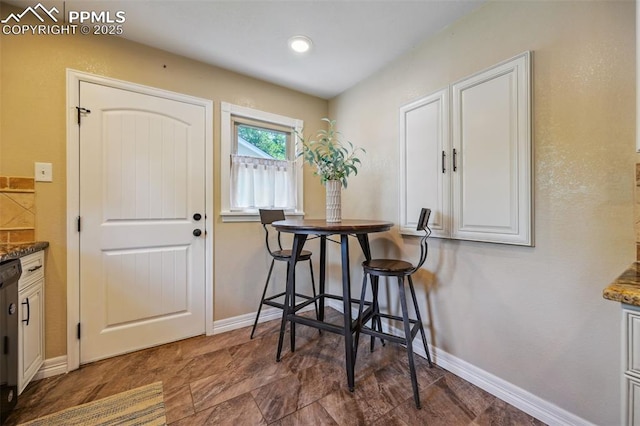 107 N Logan Ave, Colorado Springs, CO 80909 - dining area featuring baseboards and stone finish flooring