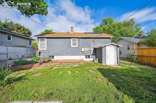 107 N Logan Ave, Colorado Springs, CO 80909 - rear view of property with a chimney, solar panels, and stucco siding
