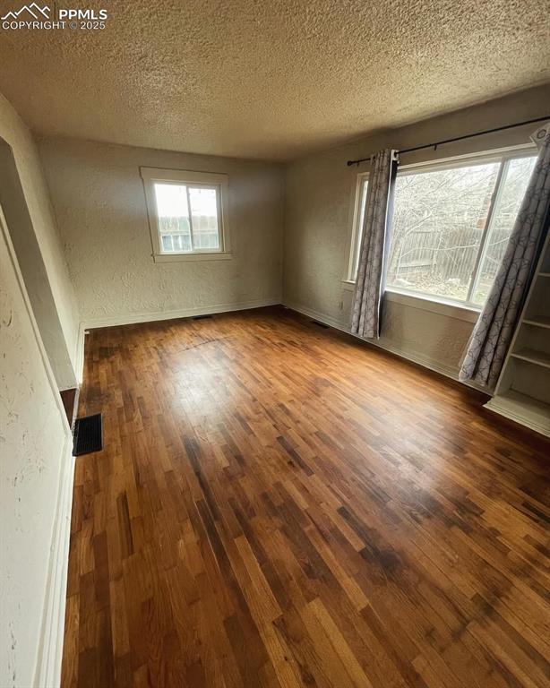 109 Cheyenne Blvd, Colorado Springs, CO 80905 - unfurnished room featuring a textured ceiling, wood finished floors, a textured wall, and baseboards