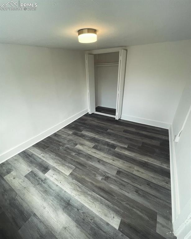 109 Cheyenne Blvd, Colorado Springs, CO 80905 - unfurnished bedroom with dark wood-style flooring, baseboards, and a closet