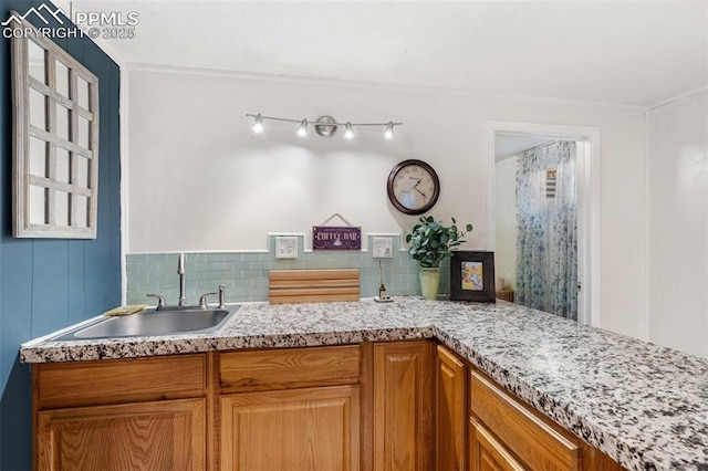 4534 Bella Dr, Colorado Springs, CO 80918 - kitchen with a sink, decorative backsplash, brown cabinetry, and ornamental molding