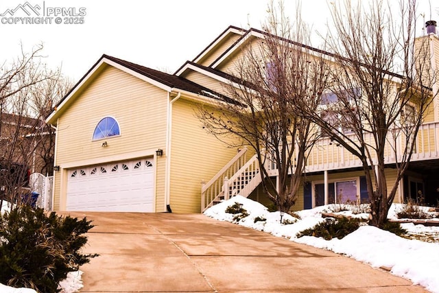 105 Pauma Valley Dr, Colorado Springs, CO 80921 - view of snowy exterior featuring a garage, concrete driveway, and stairs