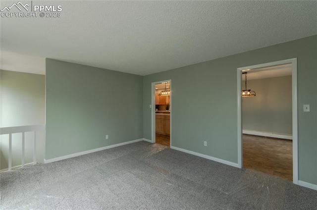 16070 Buggywhip Dr, Elbert, CO 80106 - unfurnished bedroom with a baseboard heating unit, a chandelier, carpet floors, baseboards, and ensuite bath