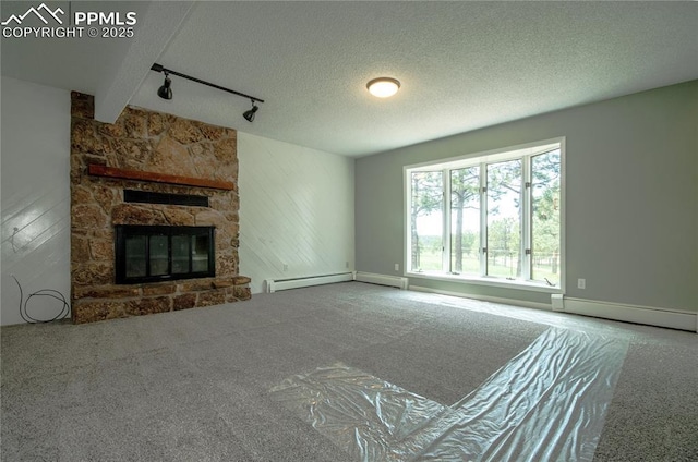 16070 Buggywhip Dr, Elbert, CO 80106 - unfurnished living room with carpet flooring, rail lighting, a fireplace, a baseboard heating unit, and a textured ceiling