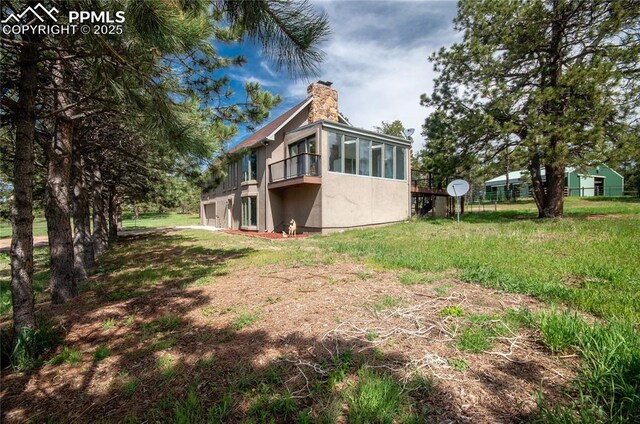 16070 Buggywhip Dr, Elbert, CO 80106 - rear view of house with a chimney, a garage, and a balcony