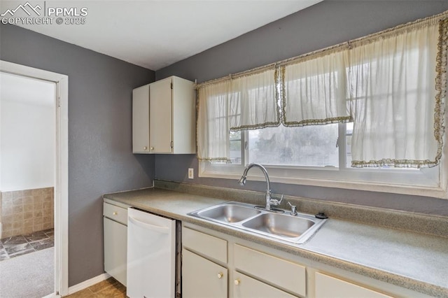 119 Arlen St, Colorado Springs, CO 80909 - kitchen featuring white dishwasher, a sink, white cabinets, light carpet, and light countertops