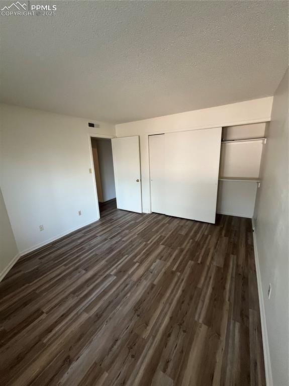 912 Acapulco Ct, Colorado Springs, CO 80910 - unfurnished bedroom with dark wood-type flooring, a textured ceiling, and baseboards