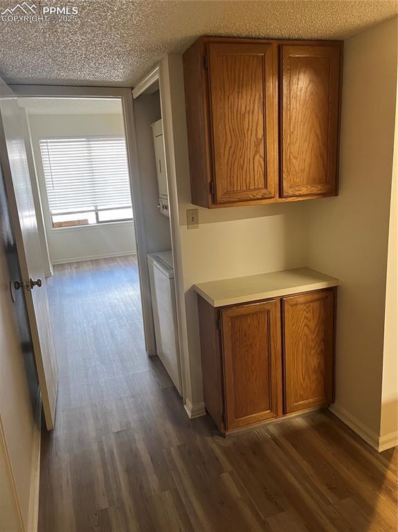 912 Acapulco Ct, Colorado Springs, CO 80910 - hallway featuring dark wood-type flooring, baseboards, and a textured ceiling