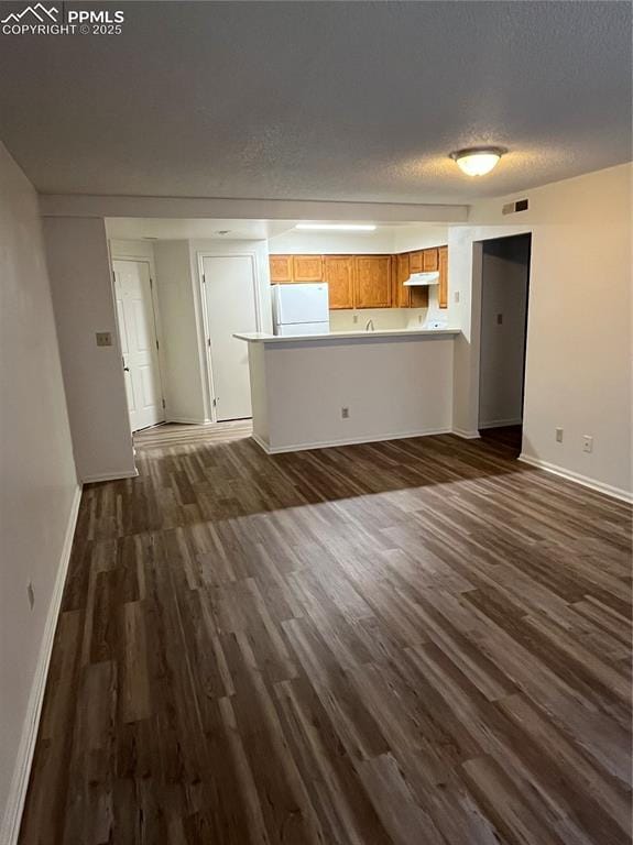 912 Acapulco Ct, Colorado Springs, CO 80910 - unfurnished living room featuring baseboards, dark wood-style flooring, and a textured ceiling