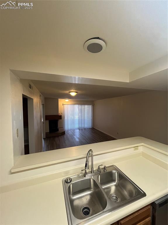 912 Acapulco Ct, Colorado Springs, CO 80910 - kitchen featuring a sink, light countertops, wood finished floors, and dishwasher