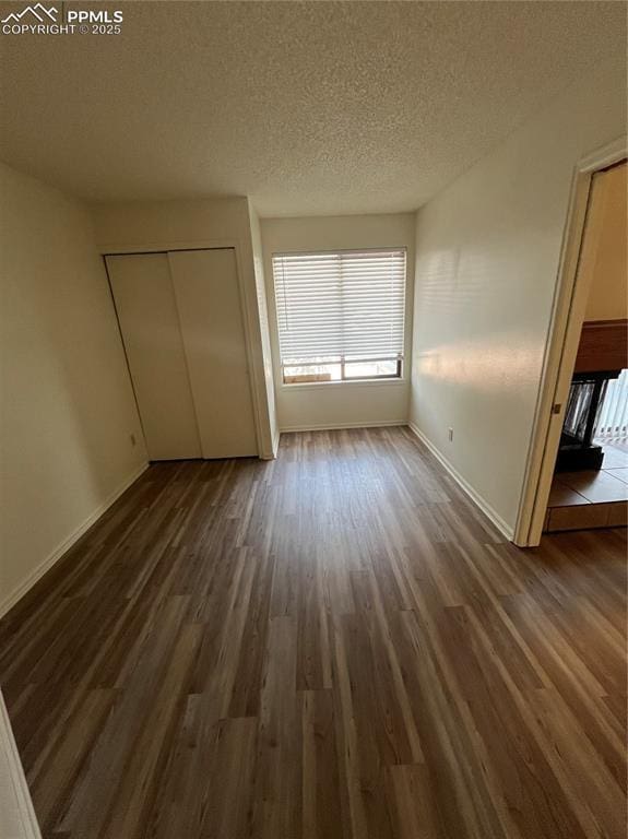 912 Acapulco Ct, Colorado Springs, CO 80910 - unfurnished bedroom featuring wood finished floors, baseboards, a closet, and a textured ceiling