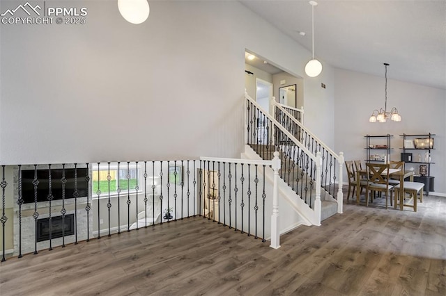13072 Westlake Pl, Broomfield, CO 80020 - staircase with a chandelier, wood finished floors, high vaulted ceiling, and baseboards