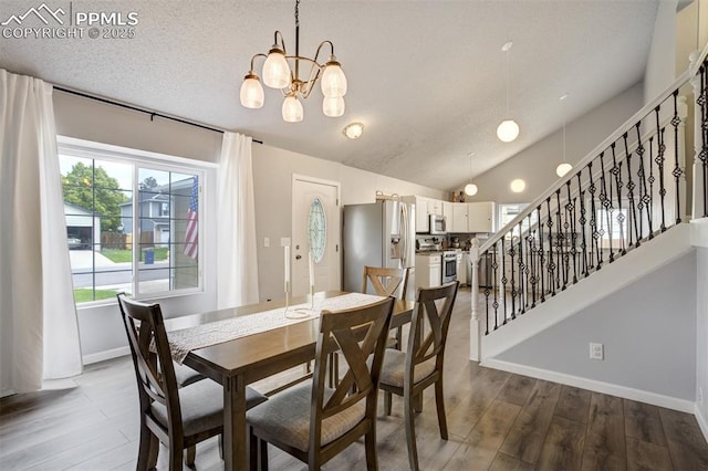 13072 Westlake Pl, Broomfield, CO 80020 - dining room featuring a chandelier, stairway, dark wood-style floors, baseboards, and lofted ceiling