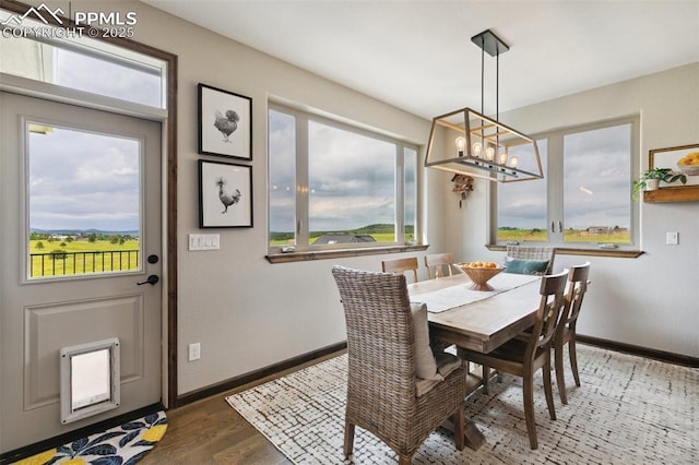 4808 Silver Nell Dr, Colorado Springs, CO 80908 - dining space with a chandelier, wood finished floors, and baseboards