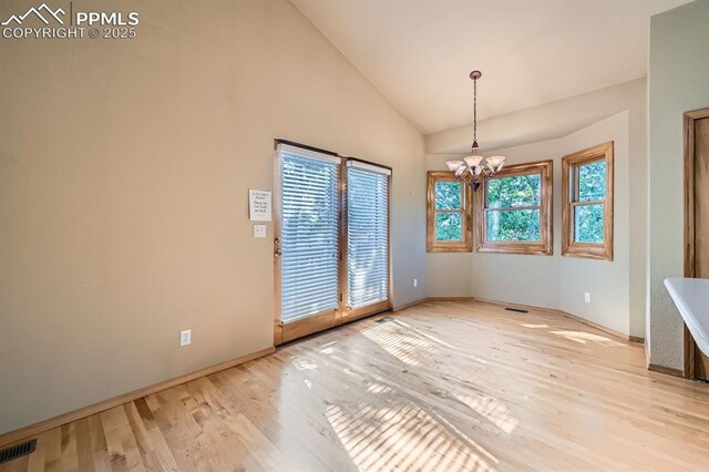 5437 Lions Gate Ln, Colorado Springs, CO 80919 - unfurnished dining area with a chandelier, light wood-style floors, and high vaulted ceiling