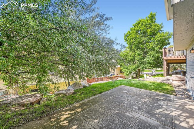 5437 Lions Gate Ln, Colorado Springs, CO 80919 - view of grassy yard featuring a patio area and a wooden deck