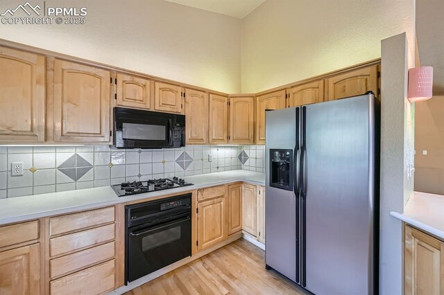 5437 Lions Gate Ln, Colorado Springs, CO 80919 - kitchen featuring black appliances, light brown cabinets, light wood finished floors, decorative backsplash, and light countertops