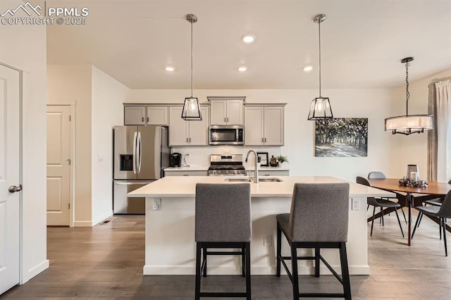 16135 Mountain Flax Dr, Monument, CO 80132 - kitchen featuring stainless steel appliances, a sink, light countertops, dark wood finished floors, and recessed lighting