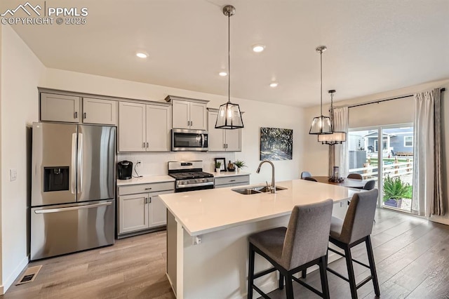 16135 Mountain Flax Dr, Monument, CO 80132 - kitchen featuring appliances with stainless steel finishes, a sink, light wood-type flooring, gray cabinets, and recessed lighting