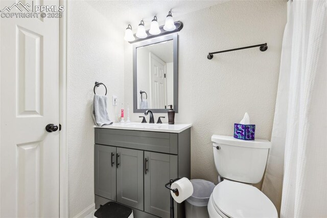 11420 Texarkanna Rd, Peyton, CO 80831 - bathroom featuring vanity, toilet, a textured wall, and a shower with curtain