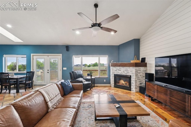 11420 Texarkanna Rd, Peyton, CO 80831 - living room with plenty of natural light, a glass covered fireplace, ceiling fan, a skylight, and wood walls