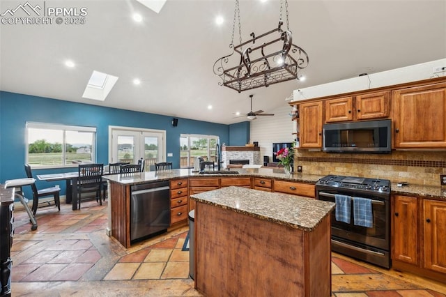 11420 Texarkanna Rd, Peyton, CO 80831 - kitchen with stainless steel appliances, a skylight, lofted ceiling, a sink, and a center island