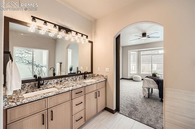 5687 Marshall Creek Dr, Colorado Springs, CO 80924 - ensuite bathroom with ceiling fan, double vanity, and baseboards