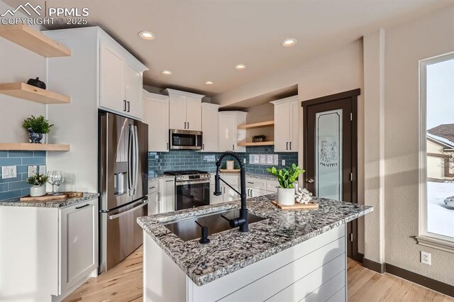 5687 Marshall Creek Dr, Colorado Springs, CO 80924 - kitchen with open shelves, appliances with stainless steel finishes, a sink, light wood-type flooring, and white cabinets