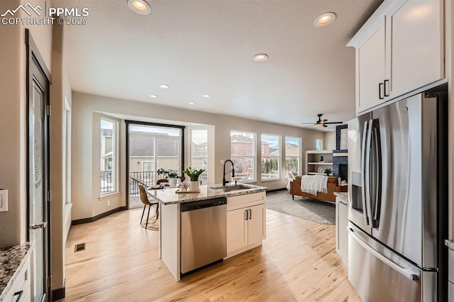 5687 Marshall Creek Dr, Colorado Springs, CO 80924 - kitchen with appliances with stainless steel finishes, a sink, open floor plan, light wood-style flooring, and recessed lighting