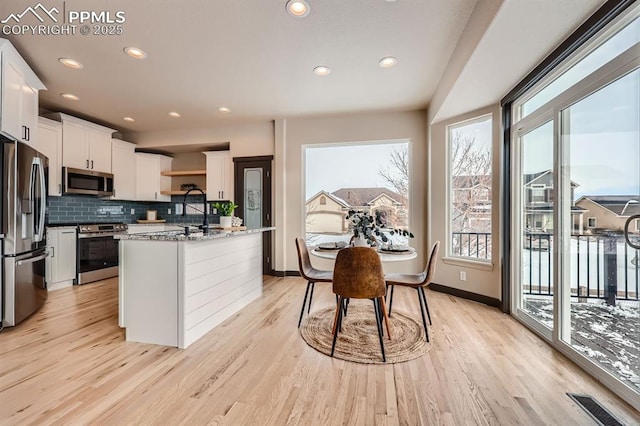 5687 Marshall Creek Dr, Colorado Springs, CO 80924 - kitchen with stainless steel appliances, decorative backsplash, light wood-style flooring, recessed lighting, and white cabinets