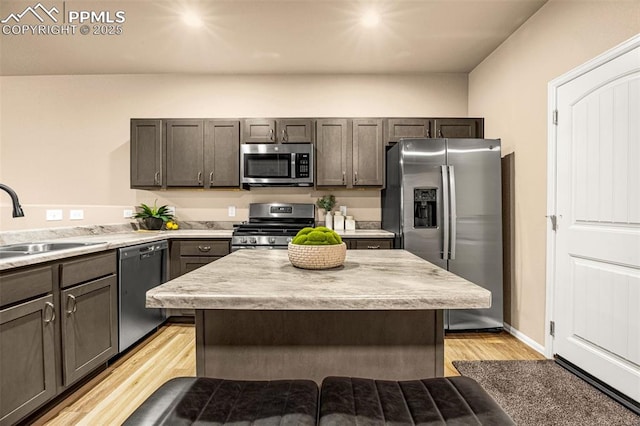 1839 Belton Hts, Colorado Springs, CO 80951 - kitchen featuring stainless steel appliances, a sink, light countertops, light wood-type flooring, and a kitchen island
