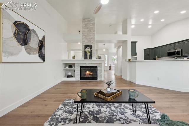 4530 Star Ridge Dr, Colorado Springs, CO 80916 - living area featuring baseboards, a large fireplace, light wood-style floors, and recessed lighting