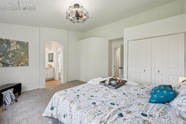 4530 Star Ridge Dr, Colorado Springs, CO 80916 - carpeted bedroom with arched walkways, a closet, baseboards, and ensuite bath