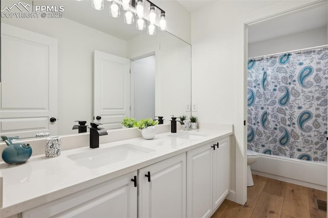 4530 Star Ridge Dr, Colorado Springs, CO 80916 - bathroom featuring double vanity, toilet, wood finished floors, and shower / bath combination with curtain