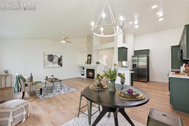 4530 Star Ridge Dr, Colorado Springs, CO 80916 - living area featuring baseboards, high vaulted ceiling, light wood-style floors, ceiling fan, and a large fireplace
