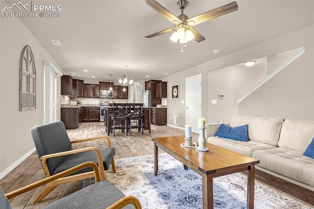 10881 Traders Pkwy, Fountain, CO 80817 - living room featuring a chandelier, a ceiling fan, light wood-type flooring, baseboards, and recessed lighting