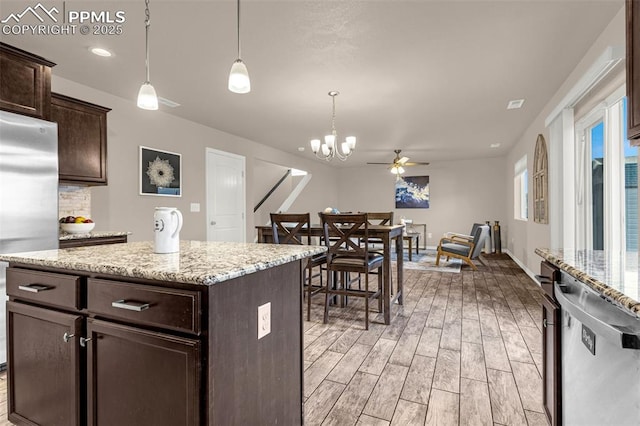 10881 Traders Pkwy, Fountain, CO 80817 - kitchen with appliances with stainless steel finishes, light wood-style floors, dark brown cabinetry, pendant lighting, and a ceiling fan