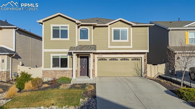 10881 Traders Pkwy, Fountain, CO 80817 - view of front of house with driveway, an attached garage, stone siding, and a shingled roof