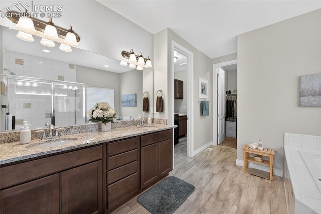 9661 Fresh Air Dr, Colorado Springs, CO 80924 - full bathroom featuring a shower stall, double vanity, a bath, baseboards, and a walk in closet