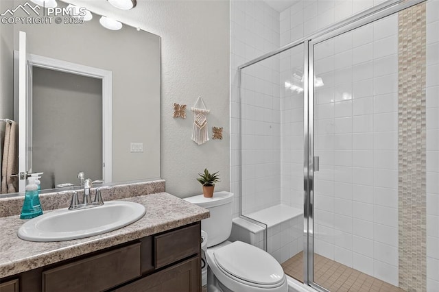 9661 Fresh Air Dr, Colorado Springs, CO 80924 - bathroom featuring vanity, toilet, a shower stall, and a textured wall