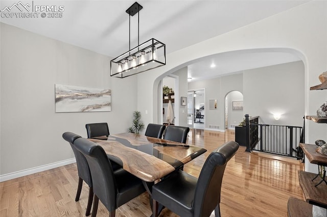 9661 Fresh Air Dr, Colorado Springs, CO 80924 - dining area featuring arched walkways, light wood finished floors, and baseboards