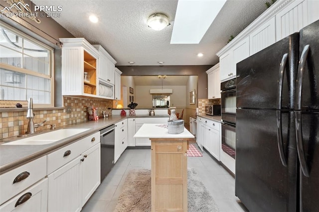 7475 Chirgiton Rd, Colorado Springs, CO 80908 - kitchen with black appliances, a sink, plenty of natural light, a skylight, and a textured ceiling